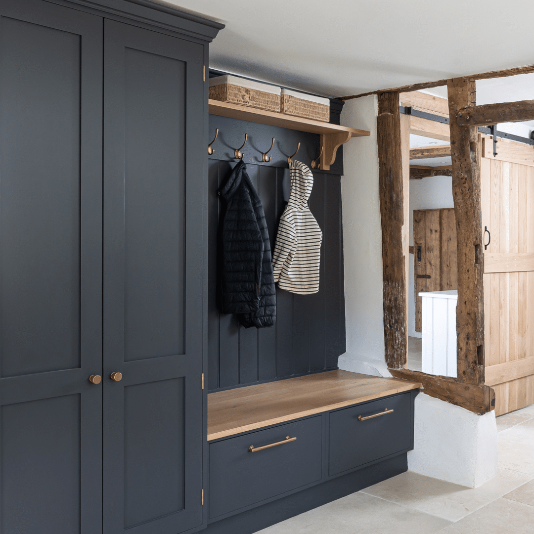 Blue painted boot room with coats hanging from hook in farmhouse.